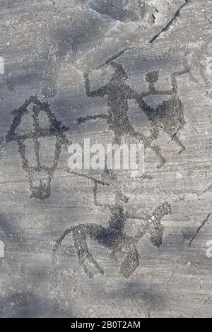 Petroglyph, Felsschnitzerei, von zwei Kriegern, die mit Schwertern und Schilden kämpfen, die von den alten Camuni-Leuten in der Eisenzeit zwischen 900 und 1200 v. Chr. geschnitzt wurden. Stockfoto