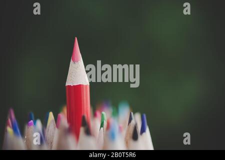 Roter Bleistift, der das Konzept des Stehens aus der Masse darstellt Roter Bleistift, der das Konzept des Stehens aus der Masse darstellt
