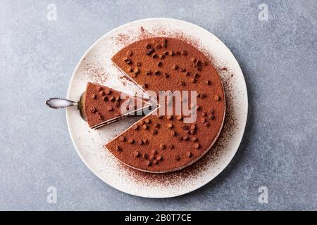 Tiramisu-Kuchen mit Schokoladendecotaion auf einem Teller. Grauer Steinhintergrund. Draufsicht. Stockfoto