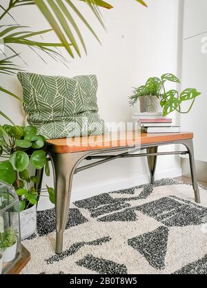 Kleine Sitzecken im skandinavischen Design mit viel natürlichem, hellem Licht und grünen Zimmerpflanzen, die eine grüne Oase zum Entspannen schaffen Stockfoto