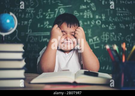 Besorgter Junge Im Klassenzimmer mit den Händen am Kopf Stockfoto