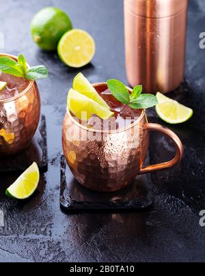 Cold Moscow Mules Cocktail mit Ingwerbier, Wodka, Limette und Minze. Grauer Steinhintergrund. Stockfoto