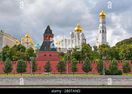 Moskau, Russland - 07. Juli 2018: Die Kremlmauer gegenüber dem Moskwa-Fluss mit dem Iwan dem Großen Bell-Turm, der Erzengel-Kathedrale und dem C. Stockfoto