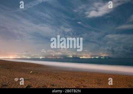 Schöne Nacht am Strand Tono's Bay oder Baia del Tono. Lange Ausstellung mit selektivem Fokus auf die Fußabdrücke des Sandes und im Hintergrund t Stockfoto