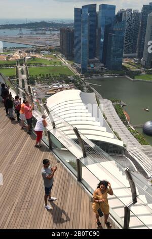 Blick über den Kopf von Touristen, die von der Aussichtsplattform Sands SkyPark aus Fotos von der Stadt Singapur machen Stockfoto