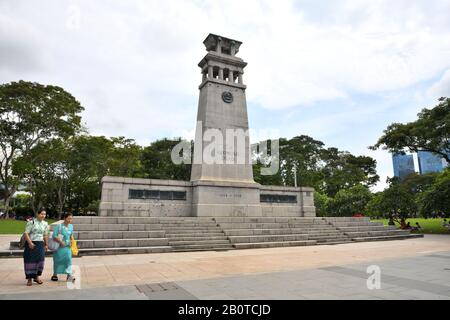 Zwei singapurische Frauen, die am Cenotaph-Weltkriegsdenkmal im Esplanade Park vorbeilaufen, Connaught DR, Singapur, Asien Stockfoto