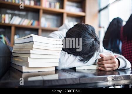 Schlafender bärtiger junger Mann Student liegt im Café an den Händen Stockfoto