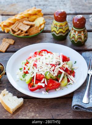 Vegetabiler bulgarischer Shopska-Salat. Holzhintergrund. Stockfoto