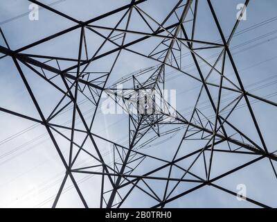 Strommenge Pylon abstrakt. Abstrakter Blick auf den Bau eines britischen Elektrizitätspylons mit klarem Himmelshintergrund. Stockfoto
