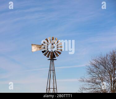 Alte, antike Windmühle, Windpumpe, mit rostigen Klingen, Flügeln oder Segeln auf dem Midwest Farm Stockfoto