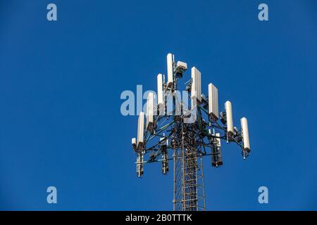 Antennenturm für drahtlose Mobiltelefone. Telekommunikationsgeräte isoliert auf blauem Himmel. Konzept der Abdeckung der Kommunikationstechnologie Stockfoto