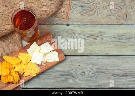 Bier und Snacks auf Holztisch legern. Stockfoto