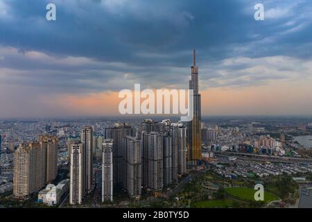 Dramatische Luftaufnahme des Landmark Building und der Skyline von Ho Chi Minh City bei Sonnenuntergang mit wunderschönen stürmischen und dunklen Wolken am Himmel Stockfoto