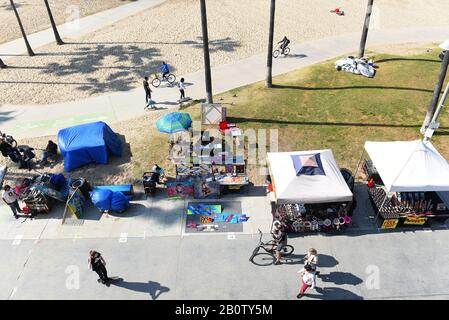 Venedig, KALIFORNIEN - 17. FEBRUAR 2020: Der Boardwalk, der aus einem hohen Winkel mit Verkäufern und Menschen, Wandern, Radfahren und Skateboarden gesehen wird. Stockfoto