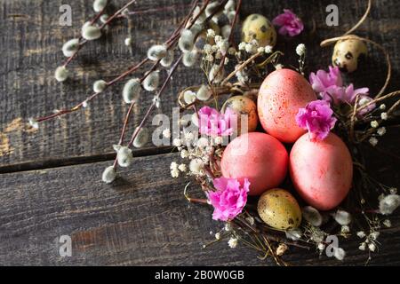 Ostereier auf Holzgrund. Pink handgefertigte ostereier in einem Korb. Kopierbereich. Stockfoto