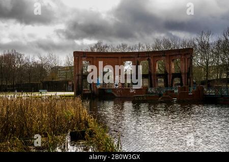 Saarbrücken, Deutschland, 1. Februar 2020, Alte rote Ziegelmauer umgeben von einem kleinen See in der saarbrücker Stadt Stockfoto