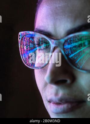 Elektronische Leiterplatte auf dem Computermonitor, die in einer Brille einer Ingenieurin reflektiert wird. Stockfoto