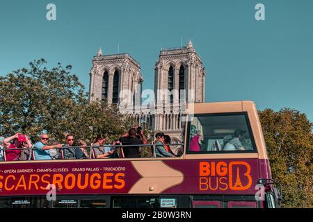 Paris, Frankreich - 14. September 2019: Sightseeing-Bus voller Touristen, die vor der Kathedrale Notre Dame in der schönen Stadt Paris vorbeifahren Stockfoto