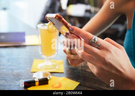 Nahaufnahme einer Frau, die auf ihrem Handy, einem Mode-Blogger, getextet hat. Stockfoto