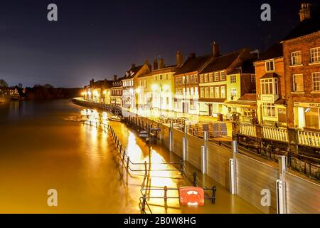 Bewdley, Großbritannien. Februar 2020. Wetter in Großbritannien: Ein beispielloses Flussniveau in Bewdley, Worcestershire, ruft dazu auf, dass lokale Notfalldienste zusammenarbeiten, um die Geschäfte und Einwohner der Stadt zu schützen. Auf beiden Seiten des River Severn in Bewdley sind Hochwasserschutzbarrieren zu erkennen, da die nächtlichen Straßenbeleuchtung in dem hier von der Bewdley Bridge aus angeschwollenen Fluss reflektiert wird, der derzeit für den Verkehr gesperrt ist. Kredit: Lee Hudson Stockfoto