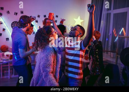 Eine Gruppe junger Leute verbringt lustige Zeit, während einer Party zu tanzen und die Musik zu genießen Stockfoto