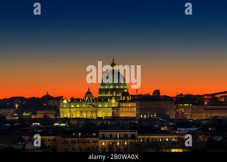 Sonnenuntergang auf der Skyline der Stadt Rom, mit der Kuppel des Petersdoms im Zentrum. Intensive gelb-orange Farbe und Horizont gegen das Licht. Stockfoto