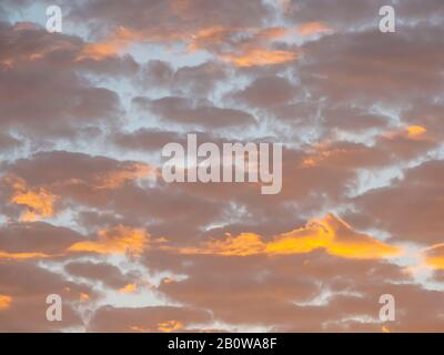 Rosarote Wolken sind ein hellblauer Himmel bei Sonnenaufgang Stockfoto