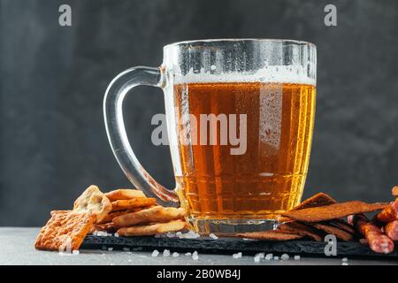 Bierglas mit Bretzel und getrockneten Würstchen Snacks liegen ganz in der Nähe Stockfoto