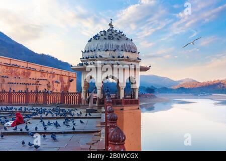 Rotunde von Amber Fort, indische Dame, die Tauben am Maotha Lake, Jaipur, Indien füttert Stockfoto