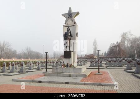 Sowjetisches Kriegsdenkmal auf dem Friedhof Olšany in Prag, Tschechische Republik. Auf der vom tschechischen Architekten Karel Beneš entworfenen Steinsäule, umgeben von Gräbern sowjetischer Soldaten, die in den letzten Tagen des Zweiten Weltkriegs gefallen und nach dem Krieg gestorben sind, befinden sich zwei Bronzestatuen von Soldaten der Roten Armee, die der tschechische Bildhauer Jaroslav Brůha (1945) entworfen hat. Nach erfolglosen Restaurierungsarbeiten, die zwischen 2009 und 2014 stattfanden, sind Gräber sowjetischer Solder abgebildet. Stockfoto