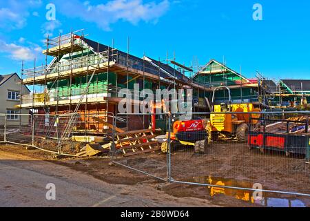 Neue Holzhäuser Baustelle am Stadtrand von Bridgend. Sicherheitszäunung rund um Standort und Anlage und Ausrüstung. Stockfoto