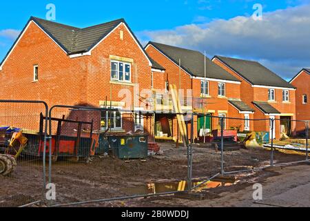 Am späten Nachmittag scheint die Sonne auf fast fertiggestellten neuen Häusern auf einem Baugelände in der Nähe von Bridgend. Stockfoto