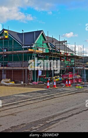 Baustelle der Häuser von Persimmon in Bridgend, S.Wales. Teilweise fertiggestellte, von Gerüsten umgebene Holzhäuser. Stockfoto