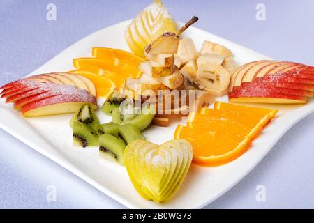 Teller mit einem frischen Obst, das professionell im Restaurant geschnitten wurde Stockfoto