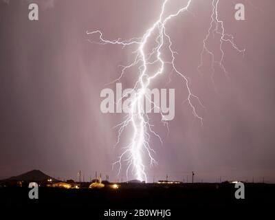 Ein massiver Blitz, der während der Saison 2007 in Monsoon hinter einem Hügel in Arlington Arizona auffällt. Stockfoto