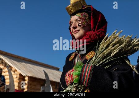 Frau in der ländlichen russischen Nationaltracht der Region Woronesch im Russischen Reich (18. Bis 19. Jahrhundert) auf dem Hintergrund des ländlichen Hauses in Moskau, Russland Stockfoto