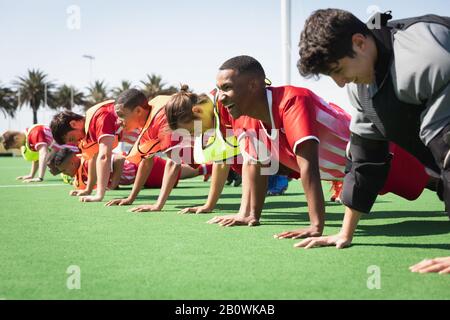 Feldhockeyspieler machen Push-Ups auf einem Feld Stockfoto