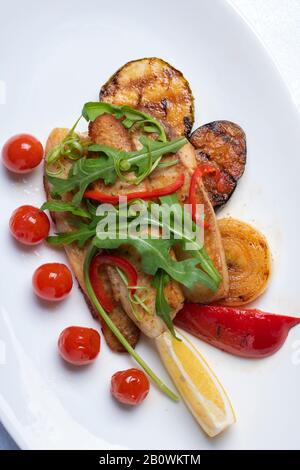 Traditionelle französische Küche. Ratatouille, Gemüseeintopf aus Zucchini, Auberginen, Paprika und Kirschtomaten mit aromatischen Kräutern. Vertikale Komposition Stockfoto
