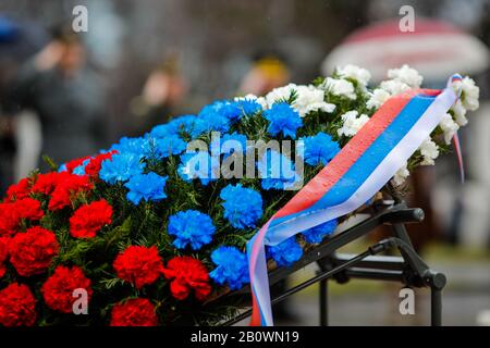 Flache Schärfentiefe (selektiver Fokus) Bild mit der russischen Flagge gefärbte Blumen auf einem Trauerkranz mit der russischen Fahne darauf während einer Regenda Stockfoto