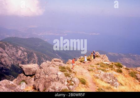 1960er Jahre, historisch, im Sommer und vier Personen auf einem felsigen Felsvorsprung auf dem Mont Capanne, Elaba, Toskana, Italien. Stockfoto