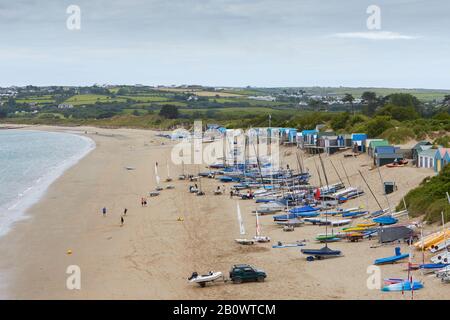 Abersoch Beach mit Segelbooten, Menschen und Strandhütten an der nordwalesischen Küste Stockfoto