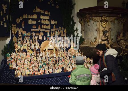 Junge Besucher beobachten die traditionelle Krippe der Lebkuchen (perníkový betlém), die in der St.-Matthias Kirche (Kostel svatého Matěje) im Stadtteil Dejvice in Prag, Tschechien, gezeigt wird. Lebkuchenfiguren des Krippenspiels werden in der Weihnachtszeit jährlich in der Kirche gebacken. Stockfoto