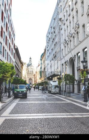 Budapest, Ungarn - 6. November 2019: Straße Zrinyi im historischen Zentrum der ungarischen Hauptstadt. Fußgängerzone, die von der berühmten St. Stephens Basilika führt. Vertikales Foto. Stockfoto