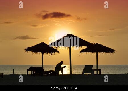 Person, die Buch am Strand bei Sonnenuntergang liest, Silhouette, Kib Hotel, Kho Khao Island, Südthailand, Südostasien, Stockfoto