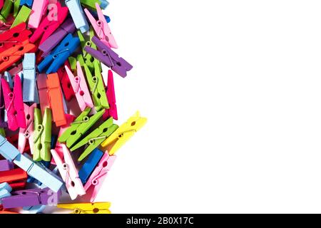 Viele bunte dekorative Holzkleiderinnen liegen im Haufen. Mehrfarbener Hintergrund. Kopierbereich. Isoliert auf weiß. Nahaufnahme. Stockfoto