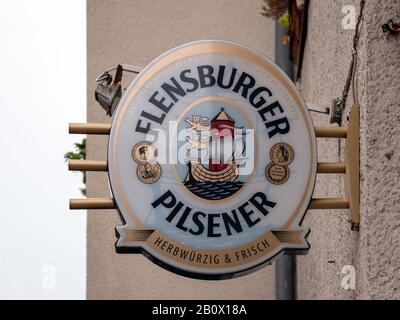 Berlin, DEUTSCHLAND - 12. FEBRUAR 2020: Werbung: Logo des deutschen Flensburger Pilsener Bieres Vor Der Mauer In Berlin Stockfoto