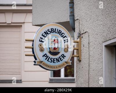 Berlin, DEUTSCHLAND - 12. FEBRUAR 2020: Werbung: Logo des deutschen Flensburger Pilsener Bieres Vor Der Mauer In Berlin Stockfoto