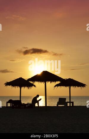 Person, die Buch am Strand bei Sonnenuntergang liest, Silhouette, Kib Hotel, Kho Khao Island, Südthailand, Südostasien, Stockfoto