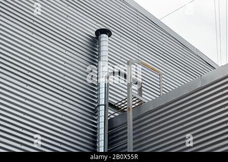 Haubenrohr an der Wand eines Industriegebäudes Stockfoto