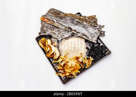 Satz traditioneller japanischer Zutat zum Garen basischer Dashi Brühe. Algen Kombu und Wakame, Katsuobushi und Trockenpilze. Isoliert auf weißem Backgrot Stockfoto